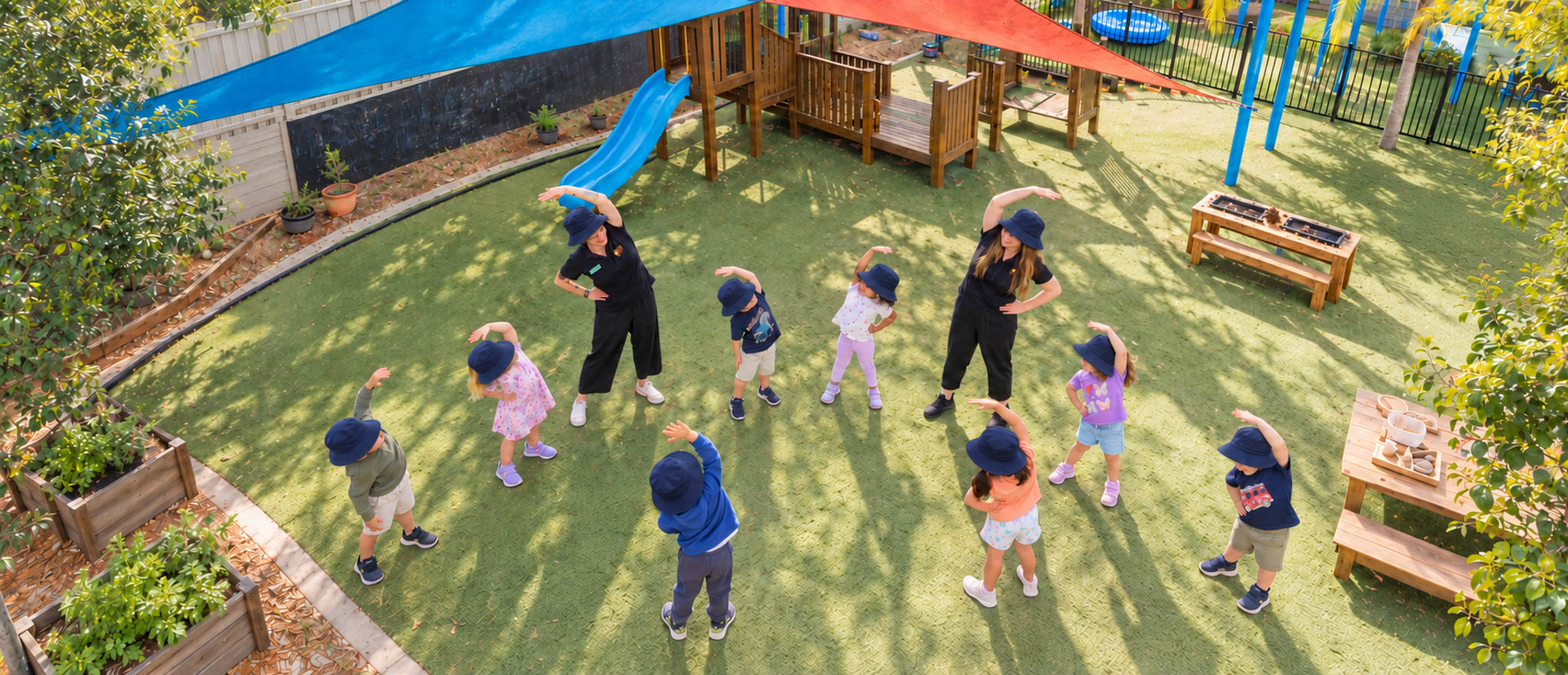 Children and educators enjoying outdoor activities on a sunny play field
