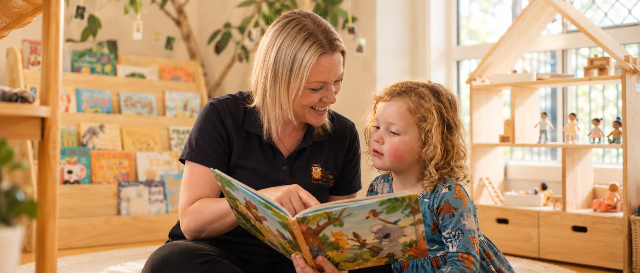 An educator and child sharing a book in a welcoming classroom
