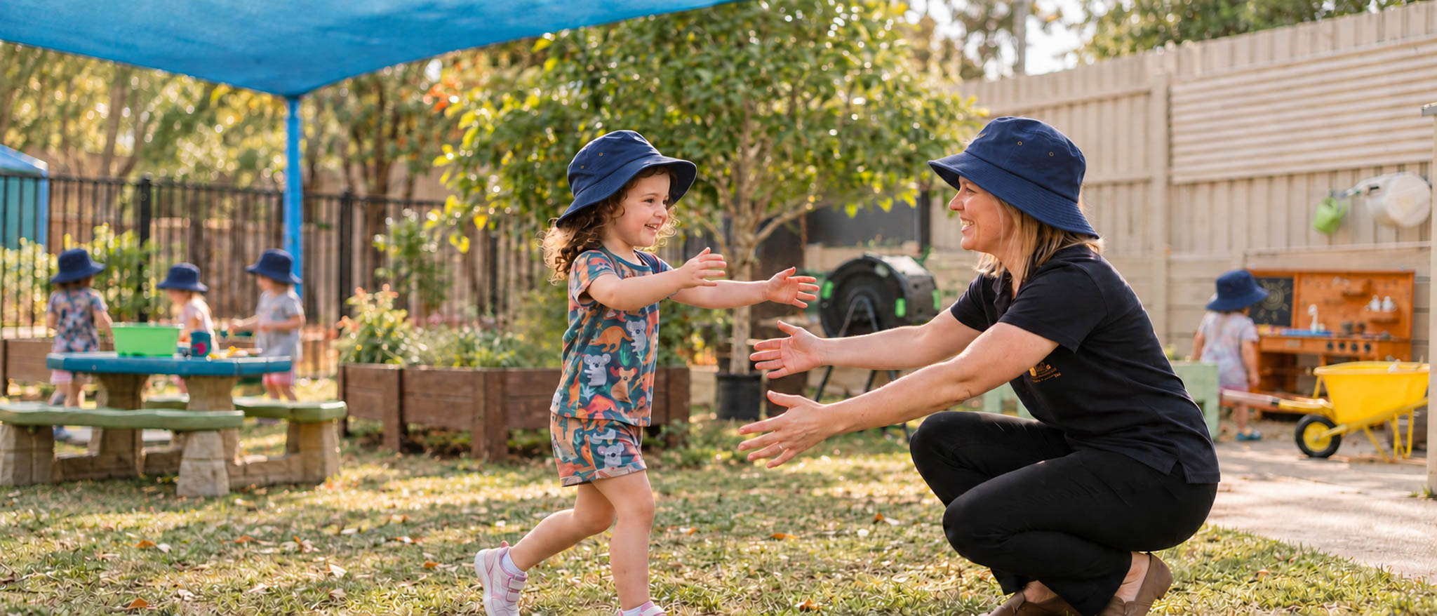 A child running into the welcoming arms of an educator in our garden